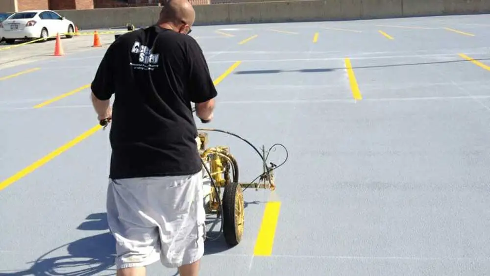man using a parking lot striper